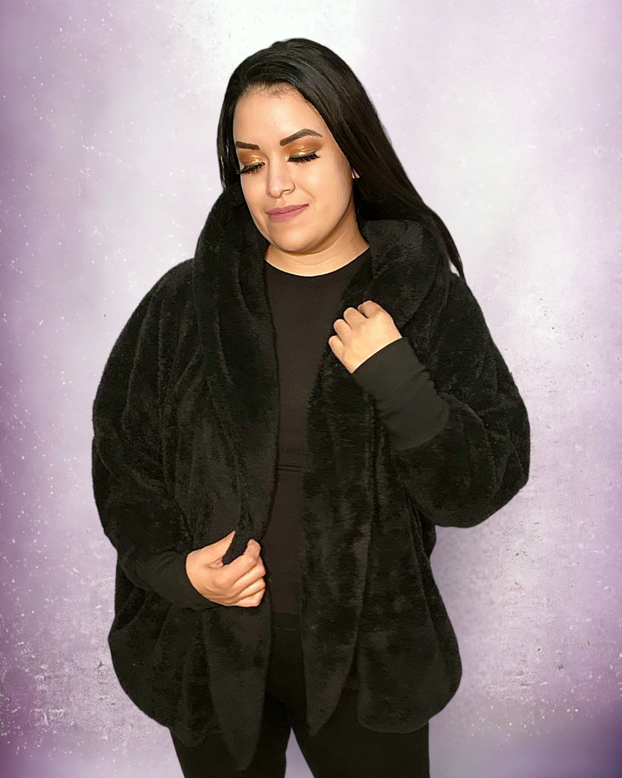 A female model wearing a black teddy hooded sherpa jacket with a relaxed collar neckline, standing against a purple background.
