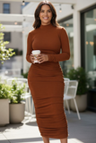 Woman in a brown dress holding a coffee cup outdoors.